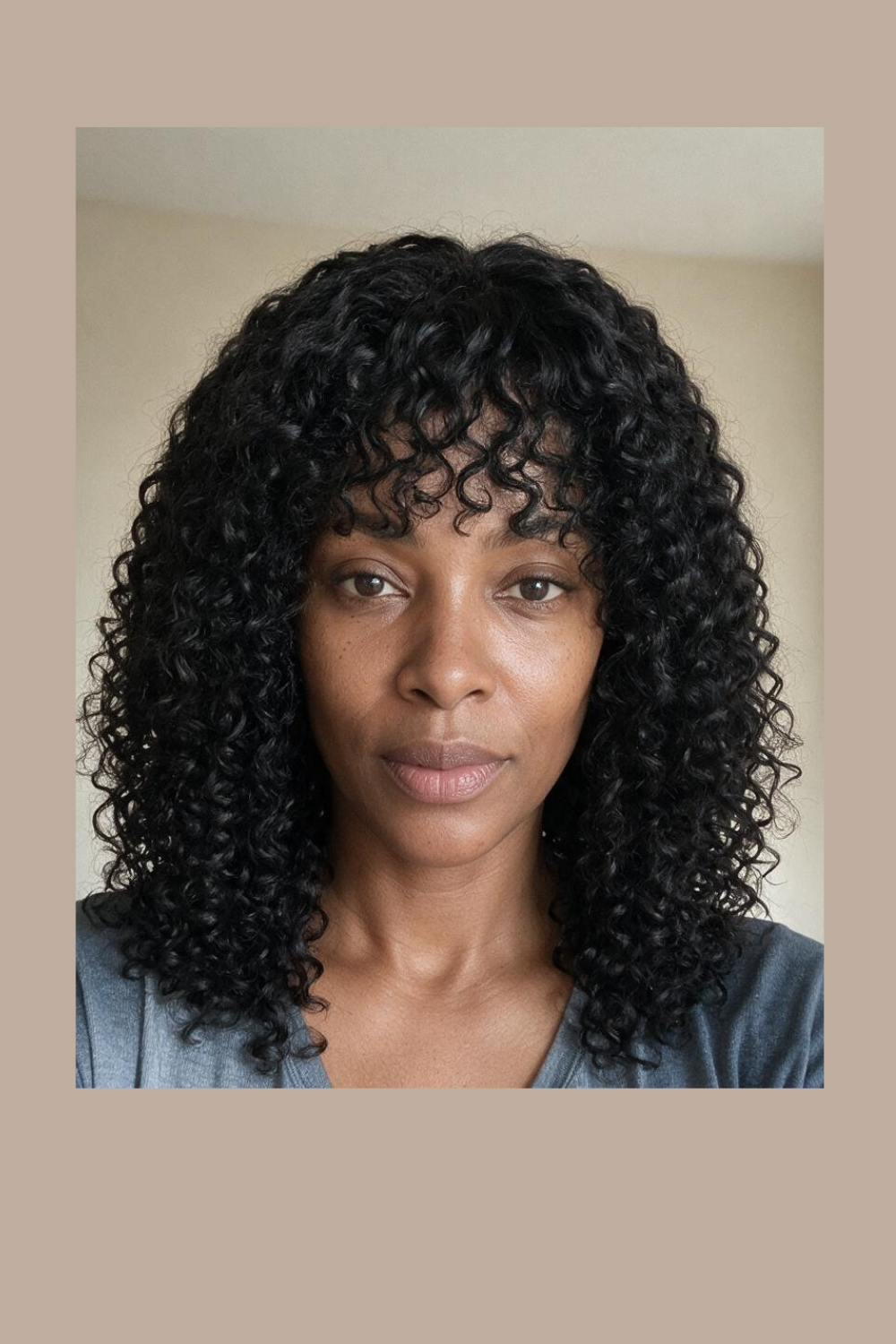 Model wearing a curly human hair wig with a fringe, shoulder length